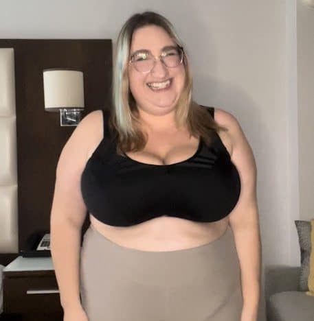 Sarah smiling in a black plus size sports bra
