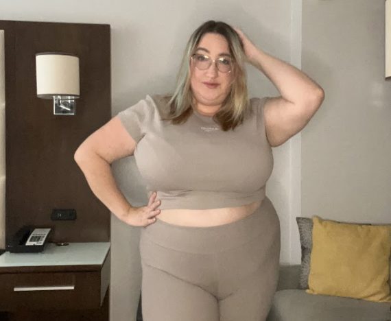 Sarah posing in a matchig taupe athletic set from Reebok